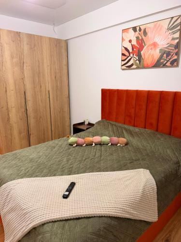 a bedroom with a bed with a remote control on it at Livia Residence II in Constanţa