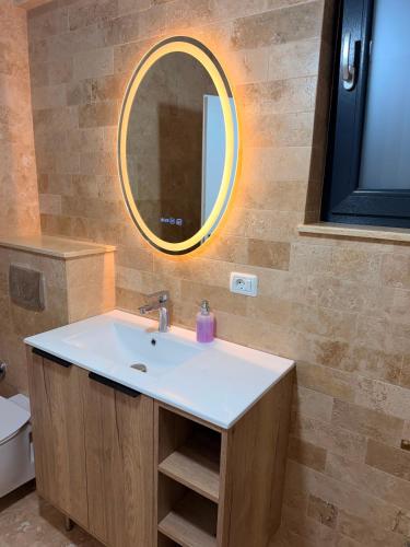 a bathroom with a sink and a mirror at Livia Residence II in Constanţa