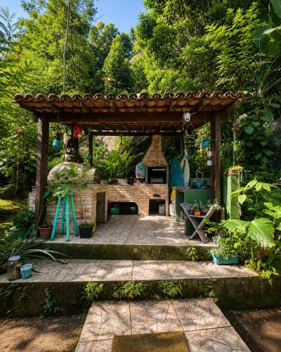 a gazebo with a fireplace in a garden at Casa da Mata Madalena in Angra dos Reis