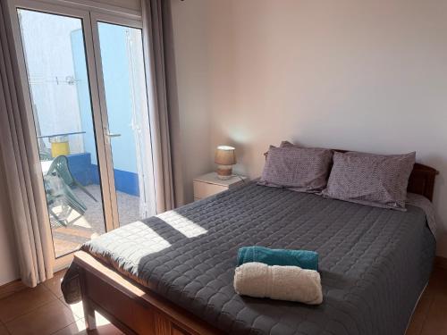 a bedroom with a large bed with a large window at Casa Sentir a Maia in Maia