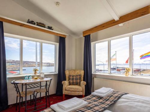a bedroom with a bed and a table and a chair at Hótel Húsavík in Húsavík