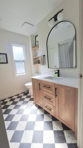 a bathroom with a sink and a mirror at Charming Inner City Home in Calgary