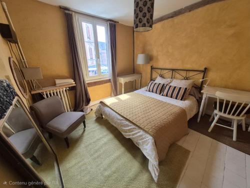 a bedroom with a bed and a chair and a window at Chambre d'hôtes Abbatiale in Bernay