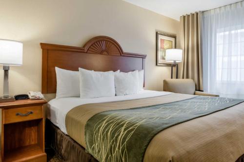 a hotel room with a large bed and a chair at Super 8 by Wyndham Great Bend in Great Bend
