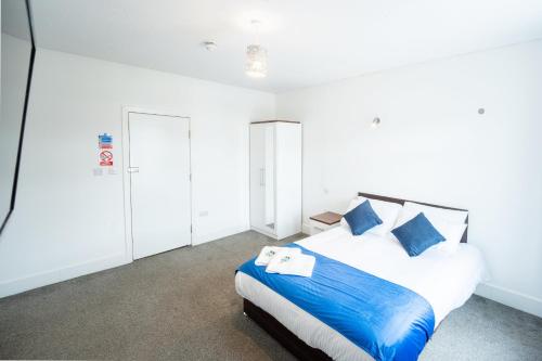 a bedroom with a large bed with blue pillows at The Bitterne Park Hotel in Southampton