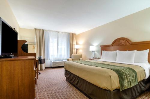 a hotel room with a large bed and a television at Super 8 by Wyndham Great Bend in Great Bend