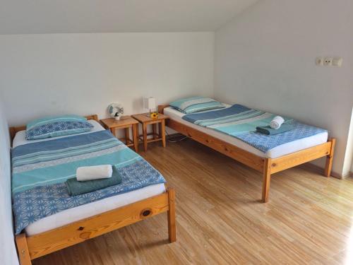two twin beds in a room with wooden floors at Apartments Jasmina in Novalja