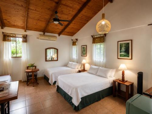 ein Schlafzimmer mit zwei Betten in einem Zimmer in der Unterkunft Kakao Lodge & Garden Río Celeste in Bijagua