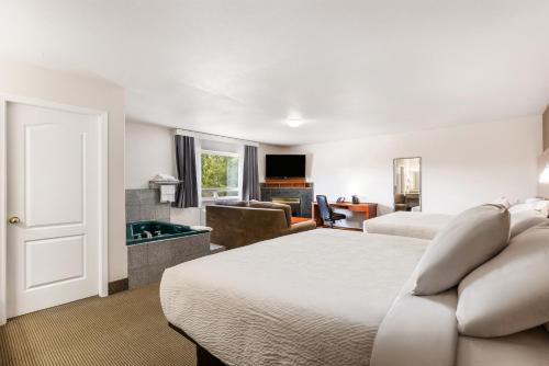 a hotel room with two beds and a pool table at Days Inn by Wyndham Valemount in Valemount
