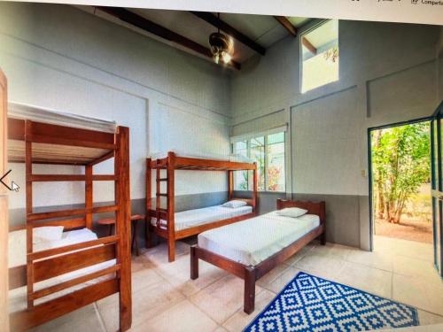 a bedroom with two bunk beds and a rug at Hostel Nosara in Playa Guiones