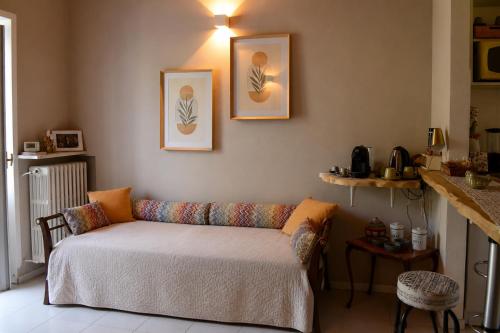 a living room with a couch and two pictures on the wall at Camelia in Arona