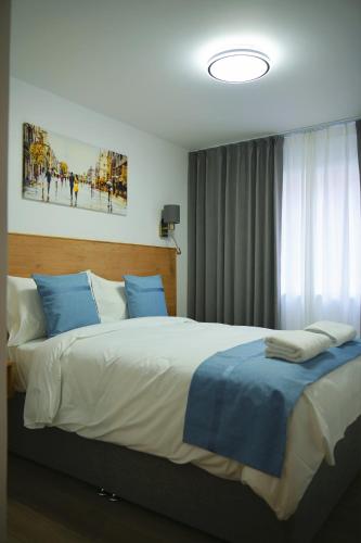 a bedroom with a large bed with blue pillows at Lavender Guest House, Near Royal Infirmary, Edinburgh in Edinburgh