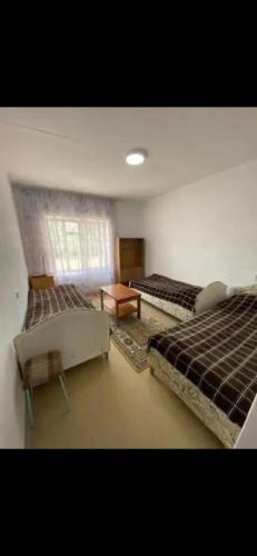 a large room with two beds and a table at House in Kyzart