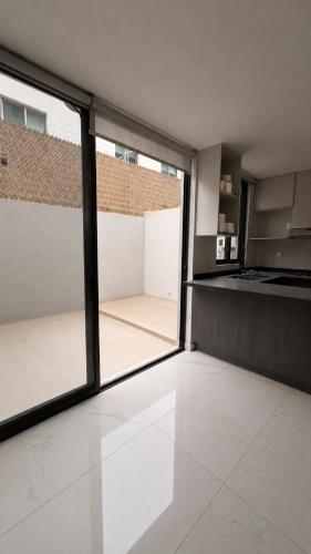an empty room with glass doors and a kitchen at Bowra World Cup House, Akron Stadium 5 in Guadalajara