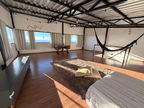 a bedroom with a bed and a hammock in it at Pousada Bela Flor in São Thomé das Letras