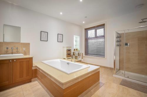 a large bathroom with a tub and a shower at Comfortable family home with amazing Seaviews in Fleetwood