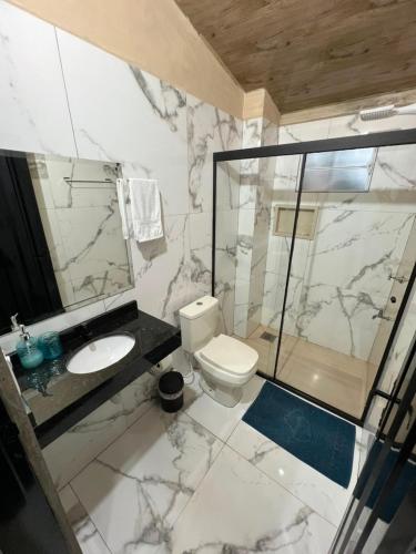 ein Badezimmer mit Toilette, Waschbecken und Dusche in der Unterkunft Hotel Suites Bambú in Minga Guazú