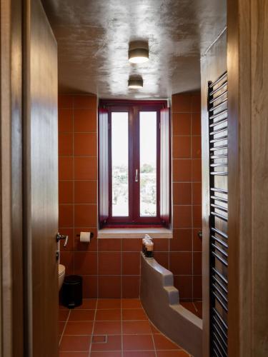 a bathroom with orange tiles and a window at Kirkinezi Kythira in Kythira