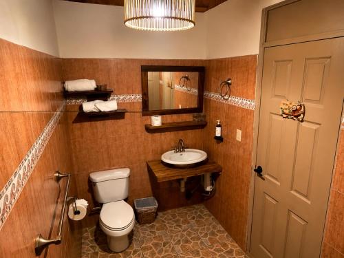 ein Badezimmer mit Toilette und Waschbecken in der Unterkunft Kakao Lodge & Garden Río Celeste in Bijagua