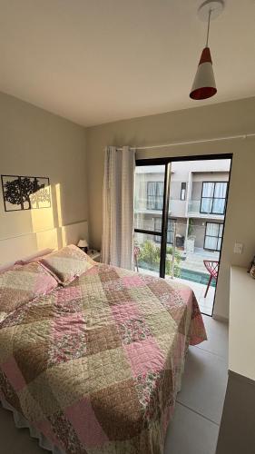 a bedroom with a bed and a large window at Flat Forte Orange - Ilha de Itamaracá in Itamaracá