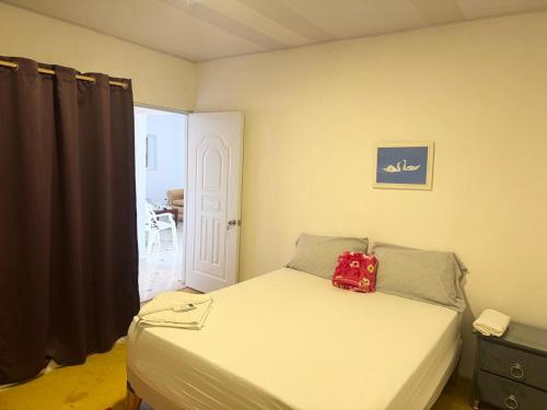 a bedroom with a bed with a red bag on it at Alojamiento Wilkenia in Ochoa