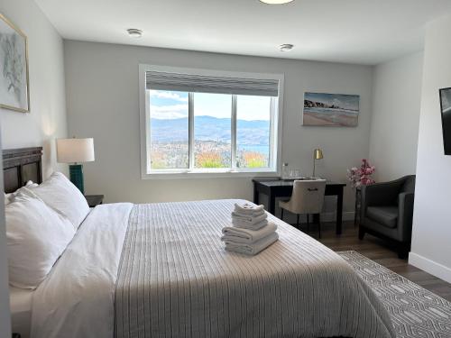 a bedroom with a bed with a desk and a window at Shannon Heights B&B in West Kelowna
