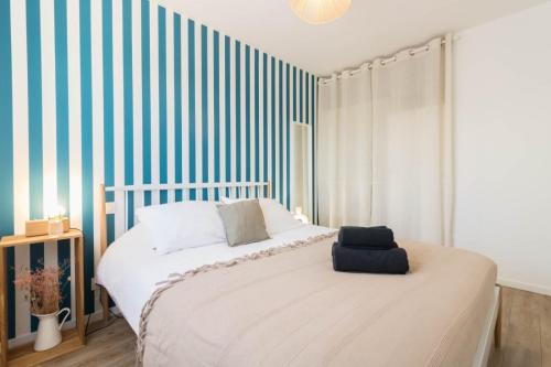 a bedroom with a bed with a striped wall at Maison Lafitte-Vigordane in Lafitte-Vigordanne