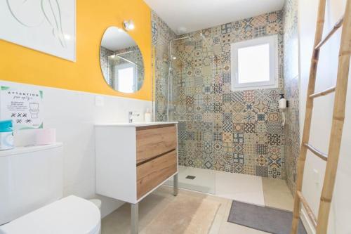 a bathroom with a sink and a toilet and a mirror at Maison Lafitte-Vigordane in Lafitte-Vigordanne