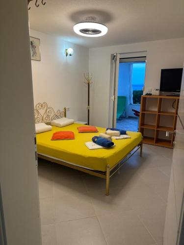 a bedroom with a yellow bed in a room at Irma Haus in Jadranovo