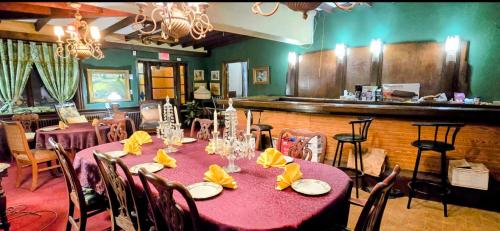 a dining room with a table and chairs and a bar at Niagara Historic Inn in Lockport