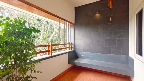 a room with a blue bench next to a window at Sivam Villa-Kovalam in Covelong