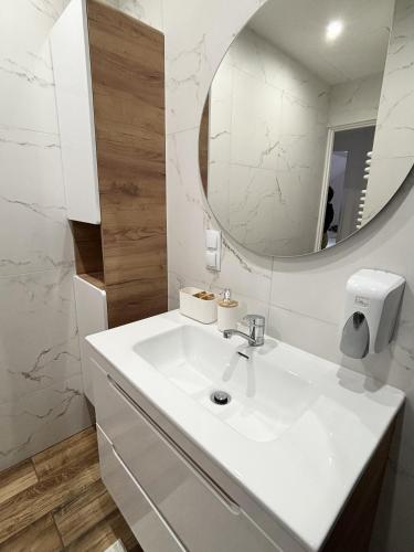 a white bathroom with a sink and a mirror at Orlikowe Wzgórze in Rabe