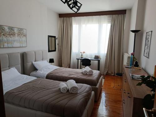 ein Hotelzimmer mit zwei Betten, auf denen Handtücher liegen in der Unterkunft Mountain Icon in Florina