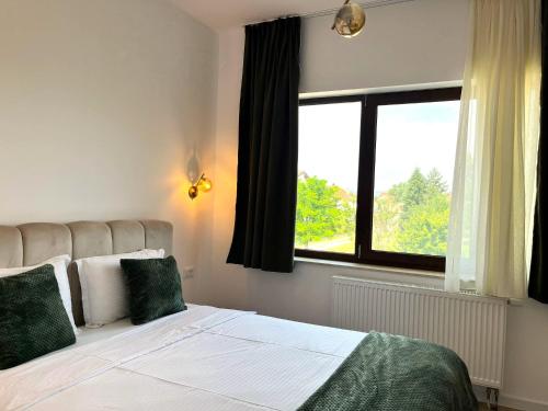 a bedroom with a large bed and a window at Villa Petra Residence - Private Parking & Village Life in Cristian