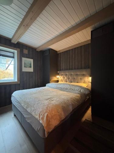 a bedroom with a large bed with lights on it at Ørnereiret in Torvetjørn