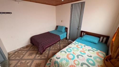 a small room with two beds and a window at Hotel Casaloma in Florián