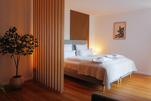 a hotel room with a bed and a plant at Black Forest Living am Marktplatz in Freudenstadt