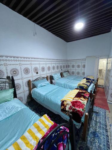 a room with three beds in a room at Ryad Cherkaoui in Fez