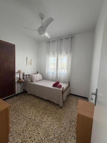 a white bedroom with a bed and a window at Hospederia Ortiz 2 in Níjar
