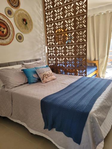 a bedroom with a bed with a blue blanket at Pontal Flat 103 in Coruripe