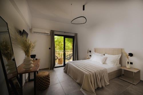 a bedroom with a bed and a door to a balcony at Abelia Boutique Rooms in Tsilivi