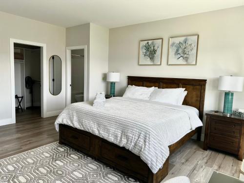 a bedroom with a large bed with two lamps and a mirror at Shannon Heights B&B in West Kelowna