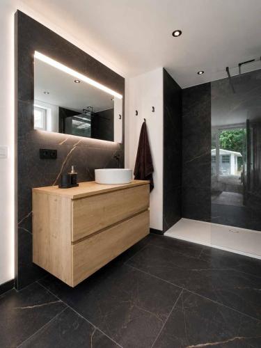 a bathroom with a sink and a mirror at Le Cocon, Jacuzzi privé Spa Francorchamps in Spa