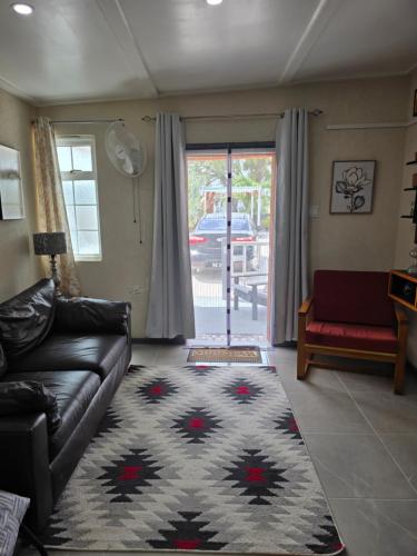 a living room with a couch and a rug at Tony's Place in Christ Church