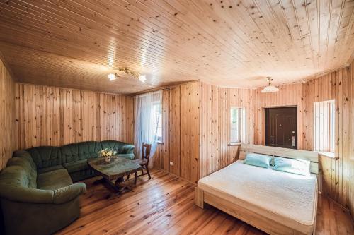 a living room with a green couch and a table at Всім бобра in Pulʼmo