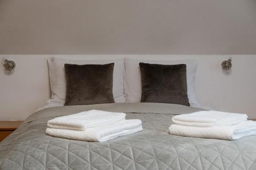 a bed with white towels on top of it at Green Valley Guesthouse in Izvoru Mureşului