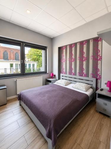 a bedroom with a large bed and a large window at Hostel Filip 2 in Gdańsk