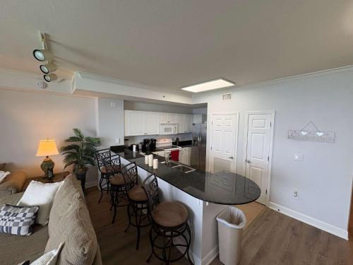 a kitchen and living room with a table and chairs at Oceanfront Condo with Shared Pool Hot Tub & Gym in Panama City Beach