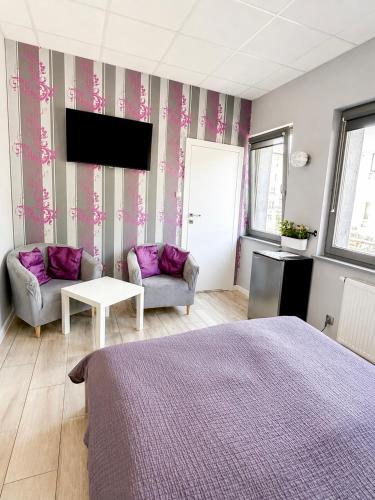 a bedroom with a bed and a couch and a tv at Hostel Filip 2 in Gdańsk