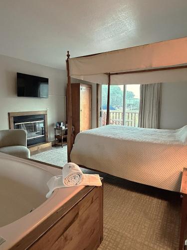 a bedroom with a bed and a tub and a fireplace at Afton House Inn in Afton